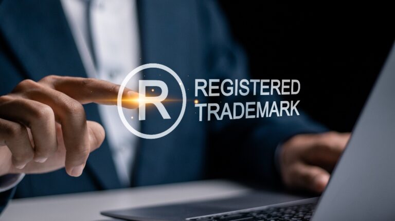 person with computer clicking on a trademark button