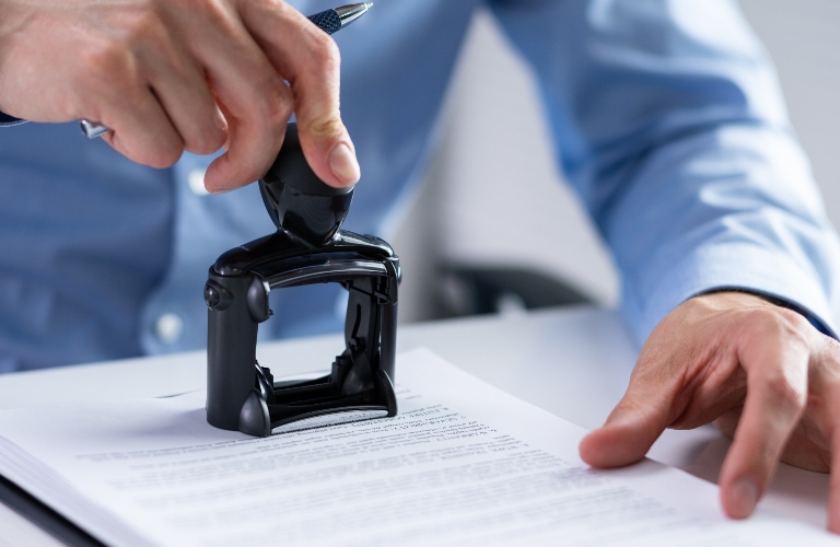 man is putting stamp on the document