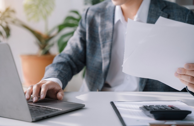 Lawyer is working at office with laptop and documents