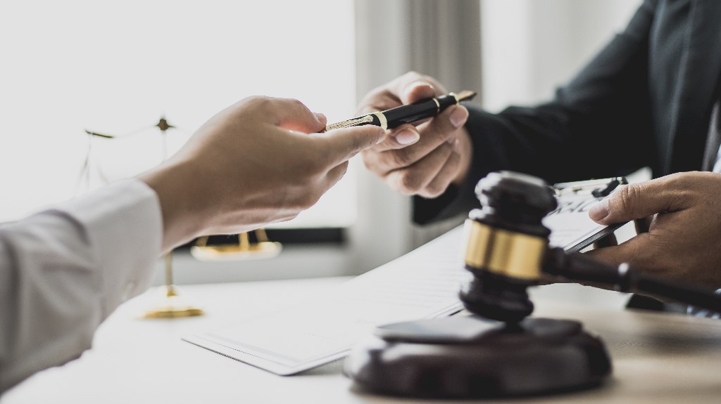 Attorney gives the client a pen to sign a document